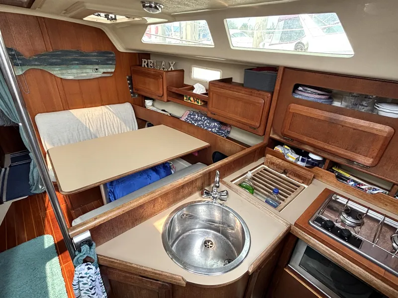 Slide: The Image of Interior of 1990 Hunter 33.5 sailboat with kitchen, dining area, and wooden cabinetry. - 35