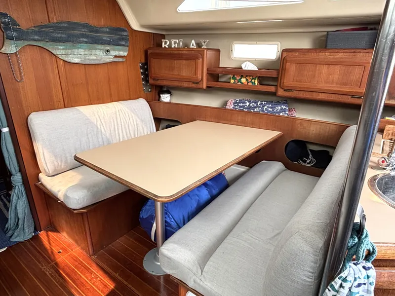 Slide: The Image of 1990 Hunter 33.5 sailboat interior with cozy dining area and wooden cabinetry. - 36