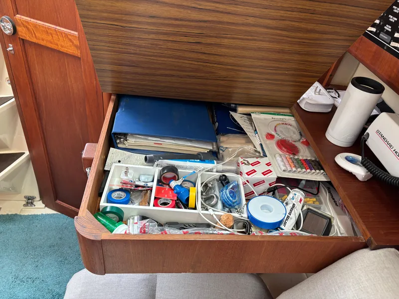 Slide: The Image of Open drawer on 1990 Hunter 33.5 boat, filled with assorted tools and supplies. - 43