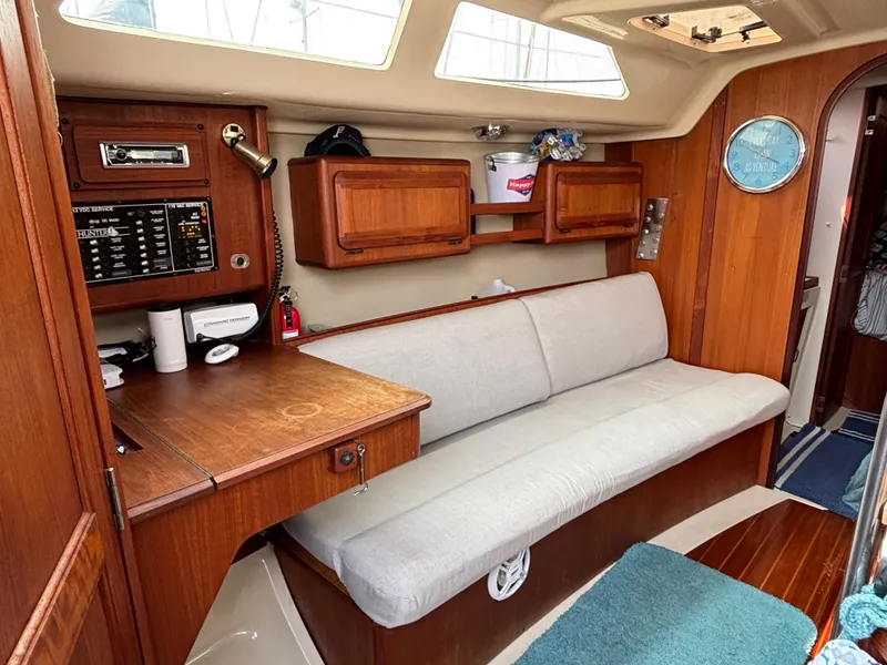 Slide: The Image of Interior of a 1990 Hunter 33.5 sailboat with wooden cabinetry and a cushioned bench. - 44