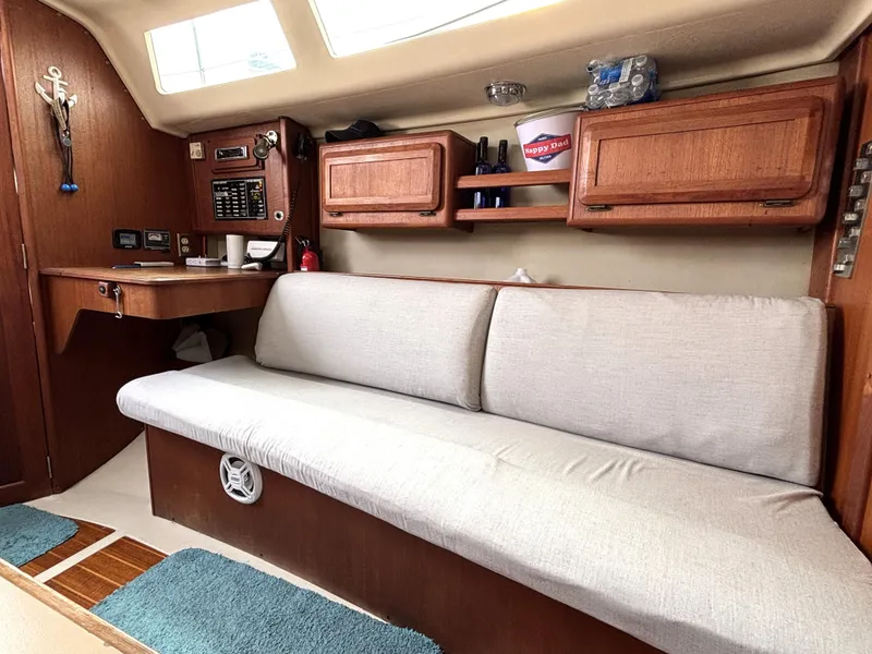 Slide: The Image of Interior of a 1990 Hunter 33.5 sailboat with wooden cabinets and a cushioned bench. - 45