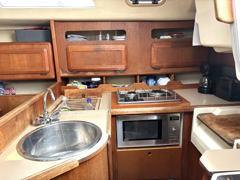 Slide: The Image of Compact kitchen in a 1990 Hunter 33.5 sailboat with stove, sink, and microwave. - 46