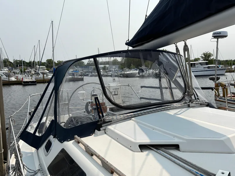 Slide: The Image of 1990 Hunter 33.5 sailboat docked at marina, featuring cockpit and steering wheel. - 6