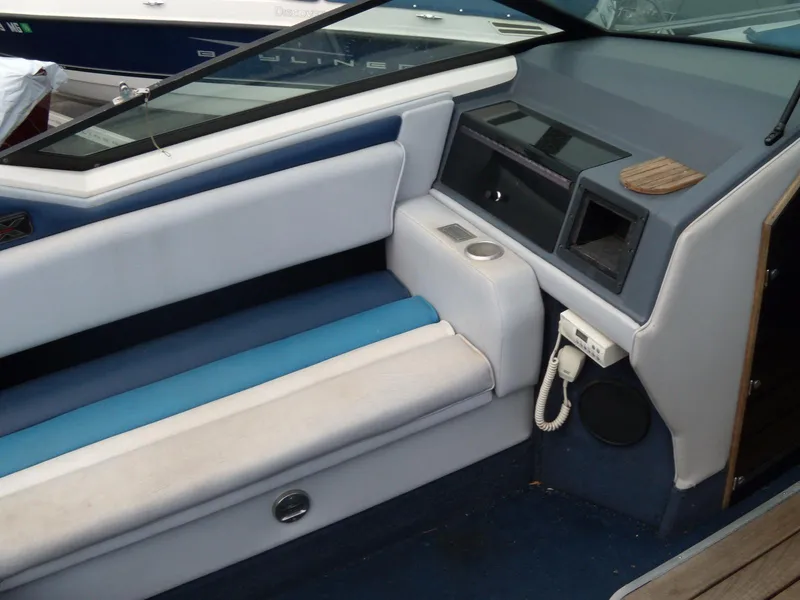 Slide: The Image of 1989 Chaparral 2300 SX Sport boat interior with blue and white seating and dashboard. - 10