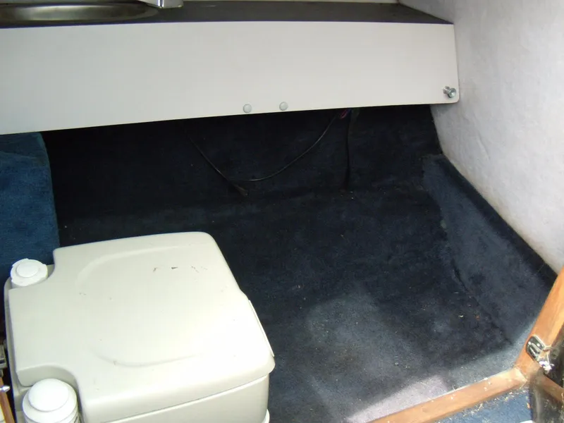 Slide: The Image of Interior cabin of 1989 Chaparral 2300 SX Sport boat with storage and portable toilet. - 12