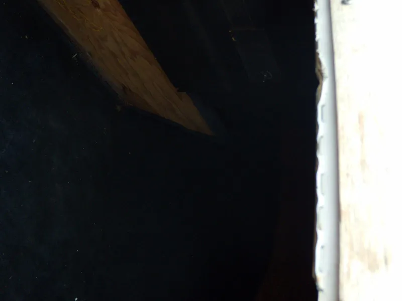 Slide: The Image of Dark interior of a 1989 Chaparral 2300 SX Sport boat, featuring wood and carpet elements. - 16