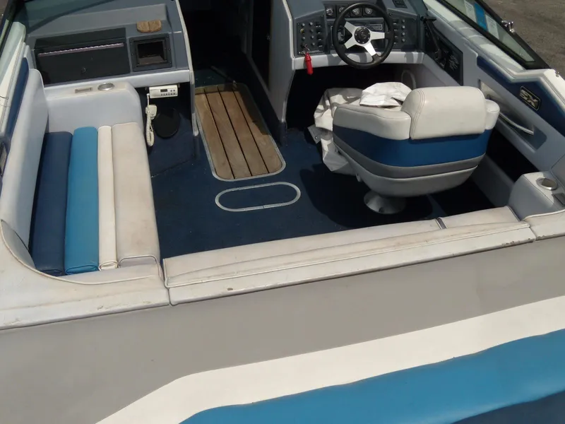 Slide: The Image of 1989 Chaparral 2300 SX Sport boat interior with blue and white seating and steering console. - 5