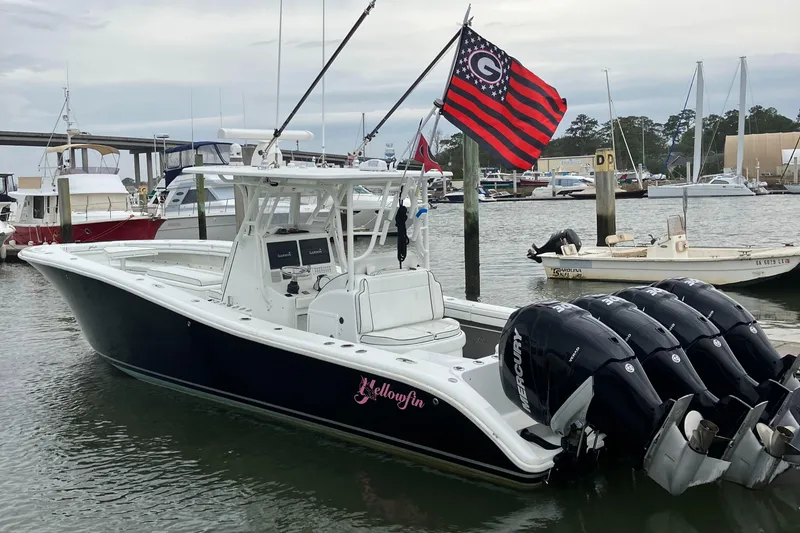 The Image of 2007 Yellowfin 36 boat docked, featuring four outboard engines and a distinctive flag. - 1