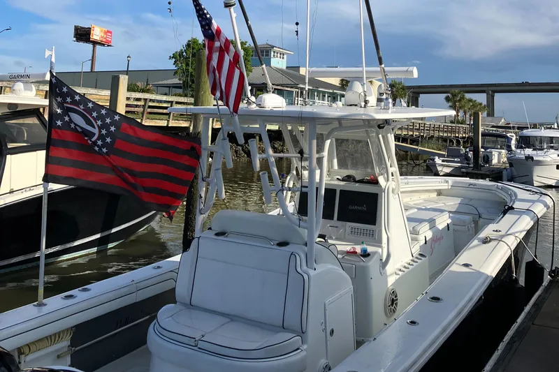 Slide: The Image of 2007 Yellowfin 36 boat docked, featuring dual flags and a spacious deck. - 12
