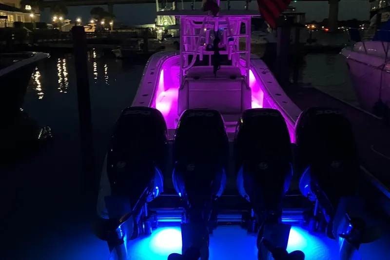 Slide: The Image of 2007 Yellowfin 36 boat with vibrant purple and blue LED lights at night. - 13