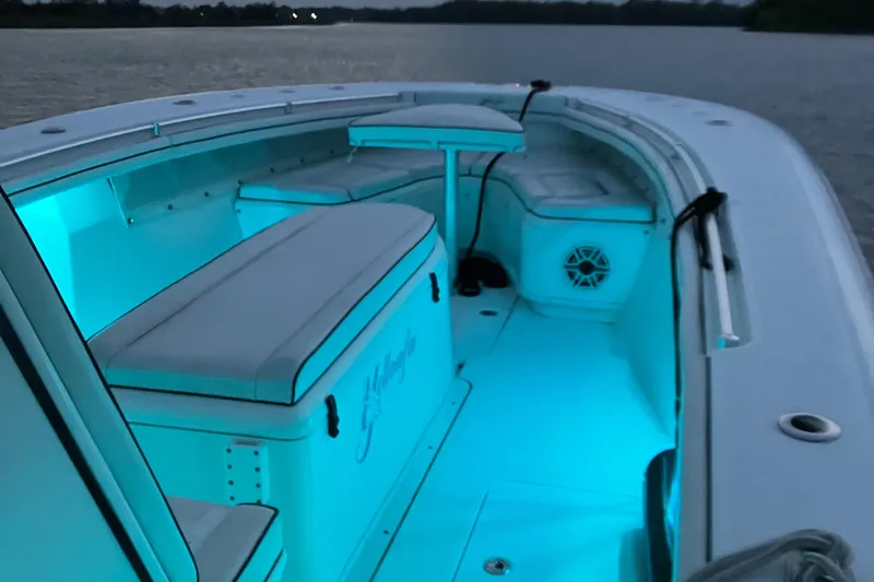 Slide: The Image of 2007 Yellowfin 36 boat interior with blue LED lighting, featuring cushioned seating and a speaker. - 16