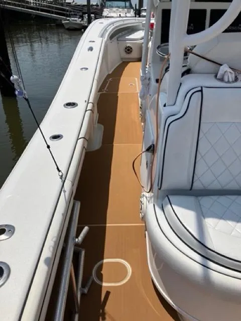 Slide: The Image of 2007 Yellowfin 36 boat interior with white seating and brown deck, docked by the water. - 19