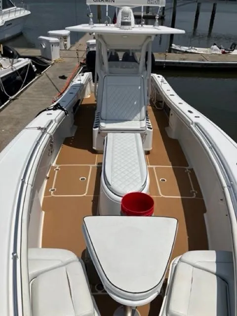 Slide: The Image of 2007 Yellowfin 36 boat interior with white seating and tan deck at a marina. - 23