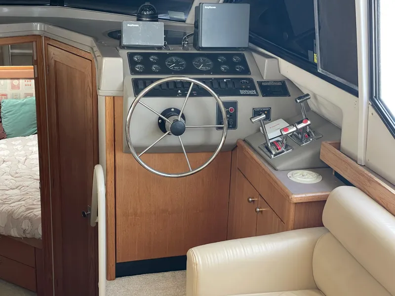 Slide: The Image of 1998 Bayliner 4087 Aft Cabin Motoryacht helm with steering wheel and control panel. - 11