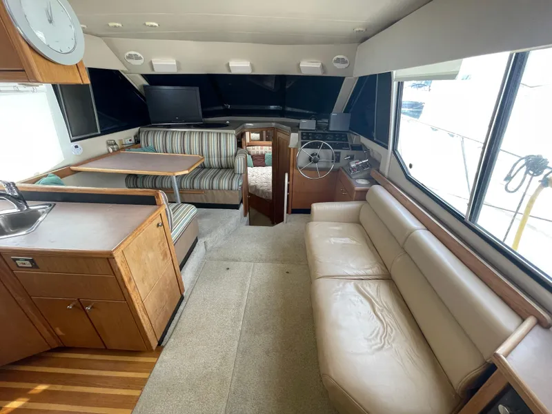 Slide: The Image of 1998 Bayliner 4087 Aft Cabin Motoryacht interior with seating, dining area, and helm. - 13