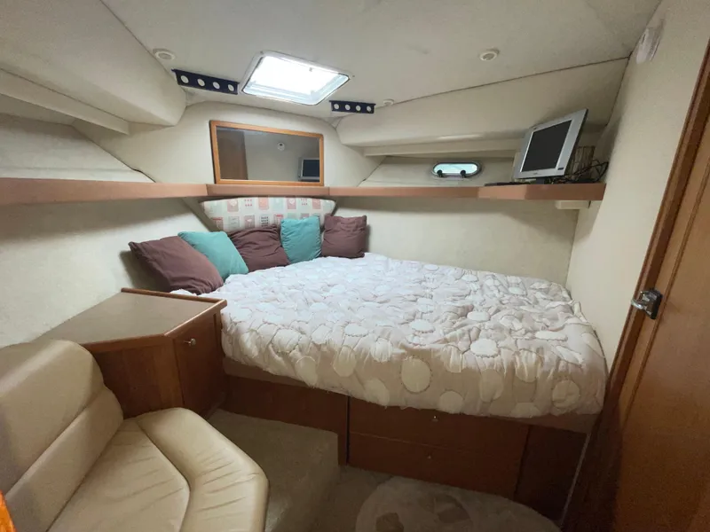 Slide: The Image of 1998 Bayliner 4087 Aft Cabin Motoryacht bedroom with bed, pillows, and TV. - 14