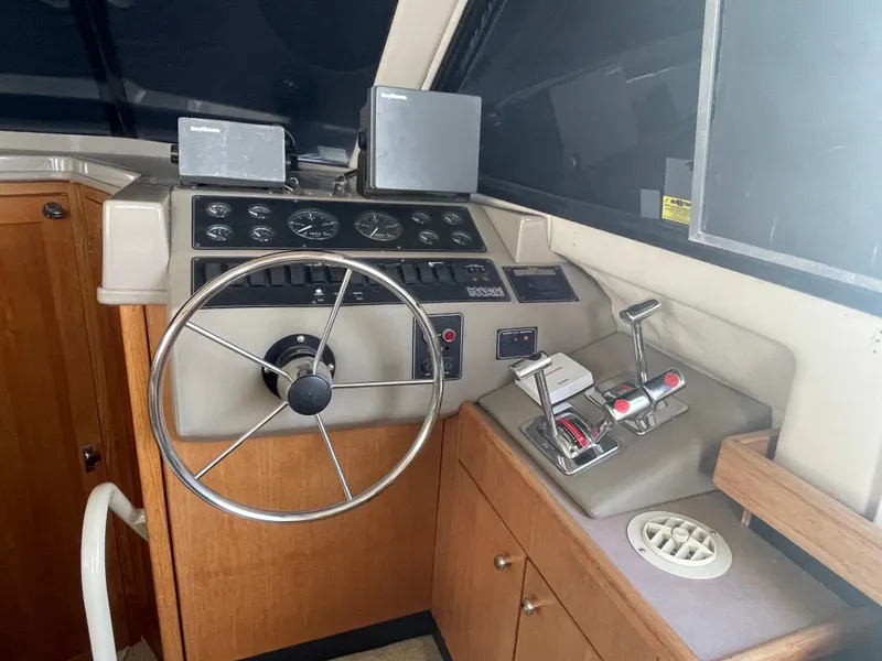 Slide: The Image of 1998 Bayliner 4087 Aft Cabin Motoryacht helm with steering wheel and control panel. - 16