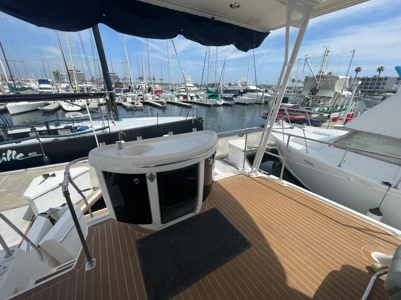 Slide: The Image of 1998 Bayliner 4087 Aft Cabin Motoryacht deck with marina view, featuring a bar counter. - 2