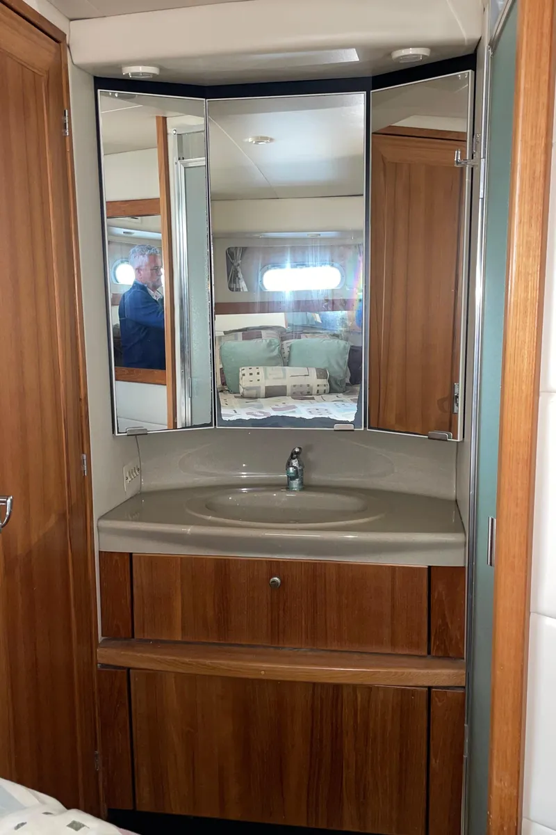 Slide: The Image of 1998 Bayliner 4087 Aft Cabin Motoryacht bathroom with wooden cabinetry and mirrored vanity. - 36