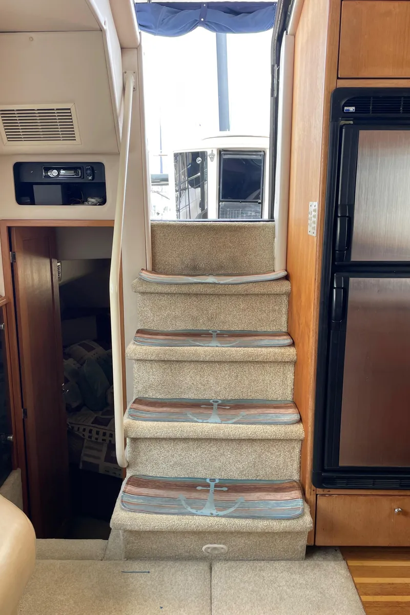 Slide: The Image of 1998 Bayliner 4087 Aft Cabin Motoryacht interior stairs with carpeted steps and wooden accents. - 40