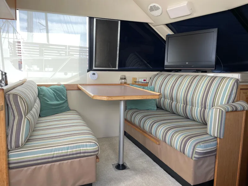 Slide: The Image of 1998 Bayliner 4087 Aft Cabin Motoryacht interior with striped seating and mounted TV. - 6