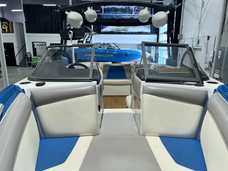 Slide: The Image of 2019 Tigé R23 boat interior with blue and white seating in a showroom. - 14