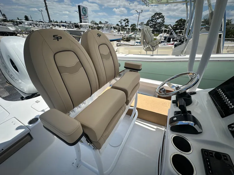 Slide: The Image of 2025 Sea Pro 230 Bay boat interior with dual tan seats and steering console. - 13