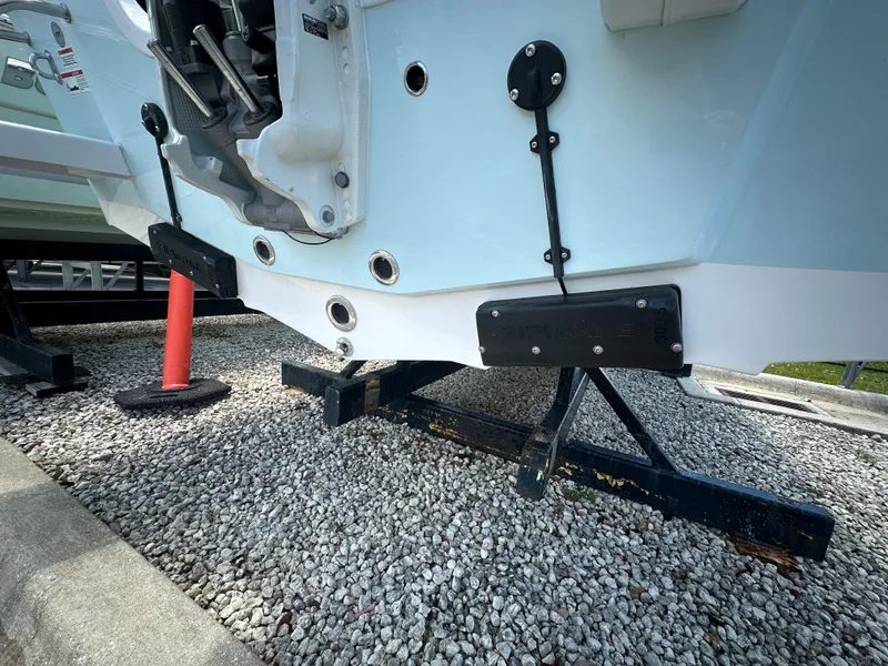 Slide: The Image of 2025 Sea Pro 230 Bay boat hull on gravel, showcasing engine mount and hardware. - 3