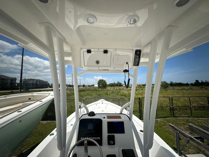 Slide: The Image of 2025 Sea Pro 230 Bay boat interior with steering console, parked outdoors. - 5