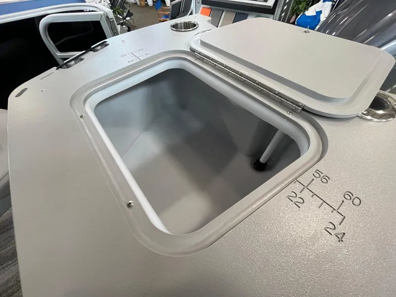 Slide: The Image of 2025 Bennington 22SXSAPG boat storage compartment with open lid and measurement markings. - 12