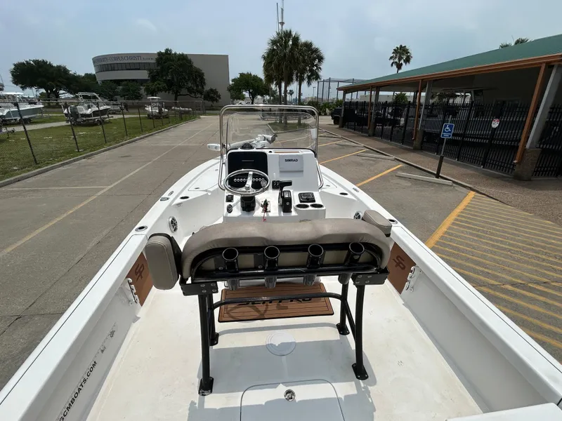 Slide: The Image of 2020 Sea Pro 228 Bay boat, docked, showcasing helm and seating area. - 14