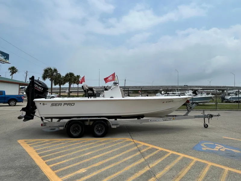 Slide: The Image of 2020 Sea Pro 228 Bay boat on trailer in parking lot, flags waving. - 4