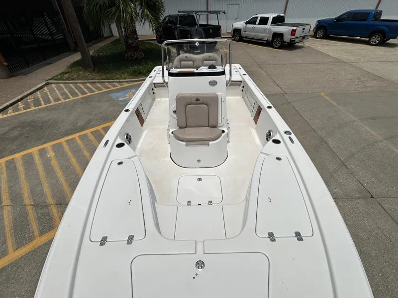Slide: The Image of 2020 Sea Pro 228 Bay boat, white deck, parked in a lot with trucks nearby. - 9