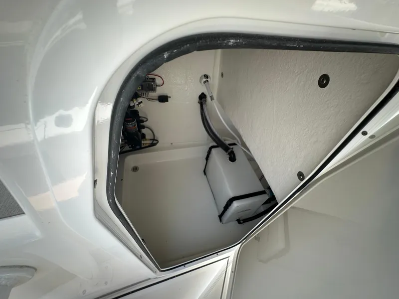 Slide: The Image of 2025 Sea Pro 250 Bay boat storage compartment with wiring and equipment. - 12