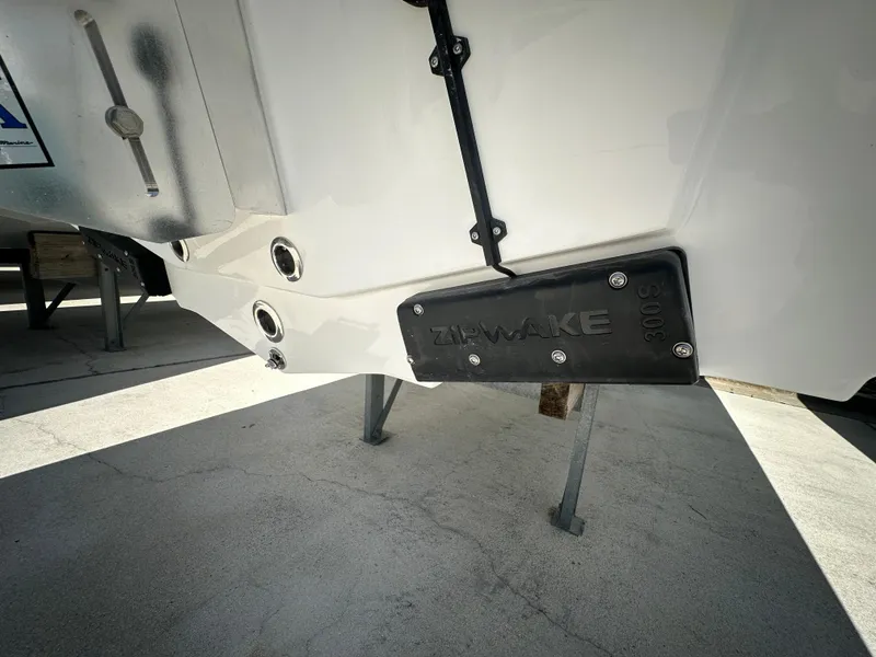 Slide: The Image of 2025 Sea Pro 250 Bay boat hull with TH-Marine wake plate, displayed on stands. - 4