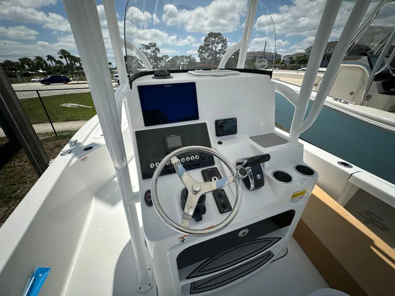 Slide: The Image of 2025 Sea Pro 250 Bay boat console with steering wheel, navigation screen, and cup holders. - 5