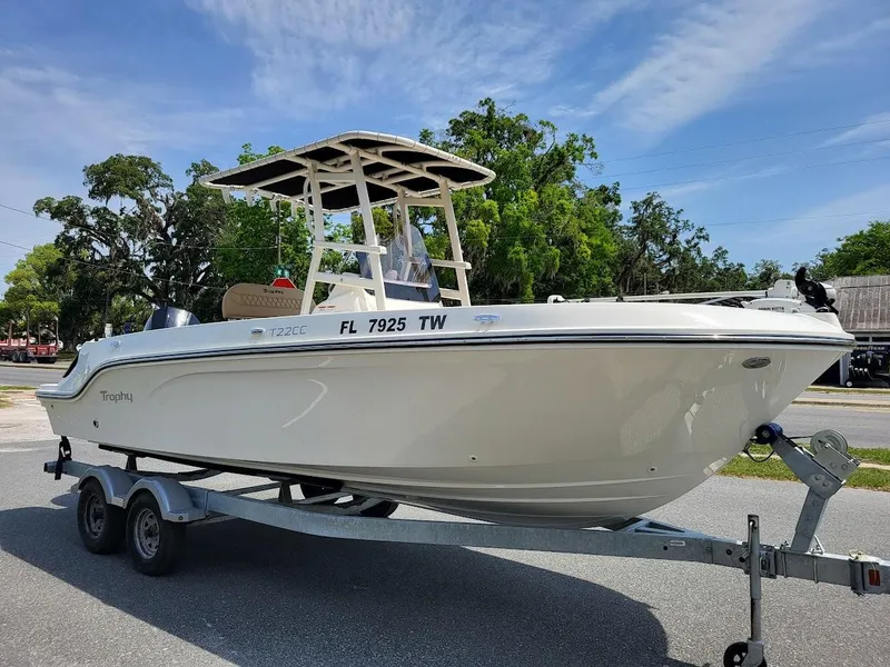 The Image of 2024 Bayliner Trophy T22CC boat on trailer, parked outdoors. - 0