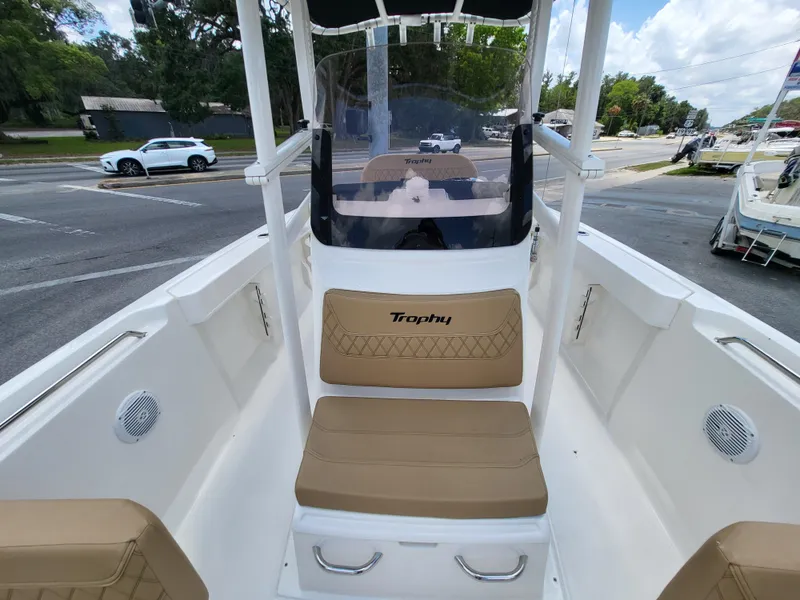 Slide: The Image of 2024 Bayliner Trophy T22CC boat interior with tan seating and steering console. - 10
