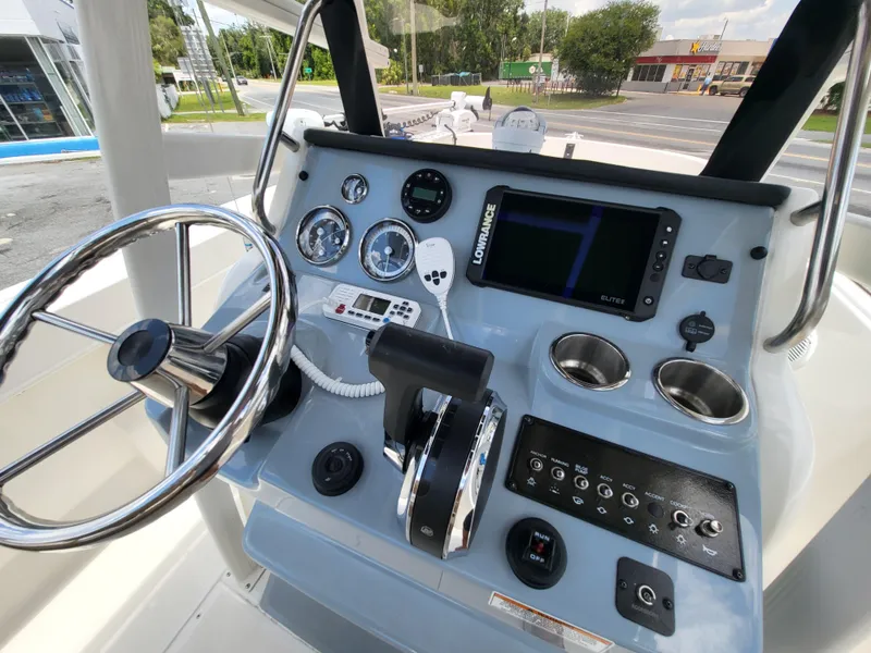 Slide: The Image of 2024 Bayliner Trophy T22CC helm with steering wheel, gauges, and navigation system. - 22