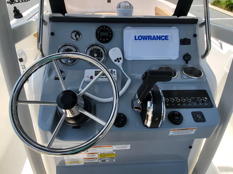 Slide: The Image of 2024 Bayliner Trophy T22CC helm with steering wheel and Lowrance navigation system. - 23