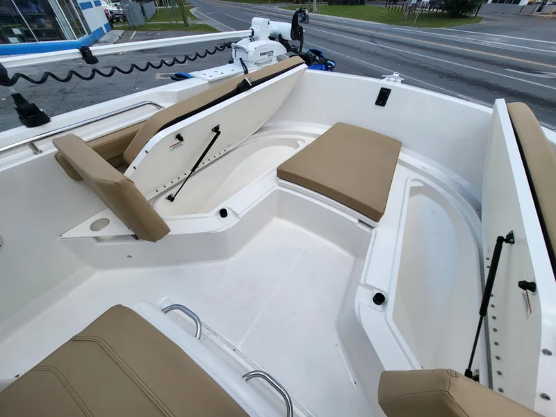 Slide: The Image of 2024 Bayliner Trophy T22CC boat interior with tan seating and storage compartments. - 9