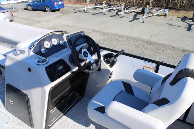 Slide: The Image of 2025 SunCatcher Select 324RC boat cockpit with steering wheel and control panel. - 11