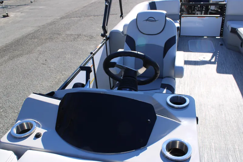 Slide: The Image of 2025 SunCatcher Select 324RC boat interior with steering wheel and cup holders. - 12