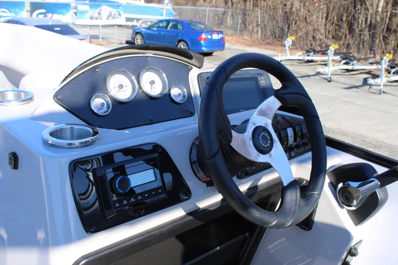 Slide: The Image of 2025 SunCatcher Select 324RC boat dashboard with steering wheel and control panel. - 13