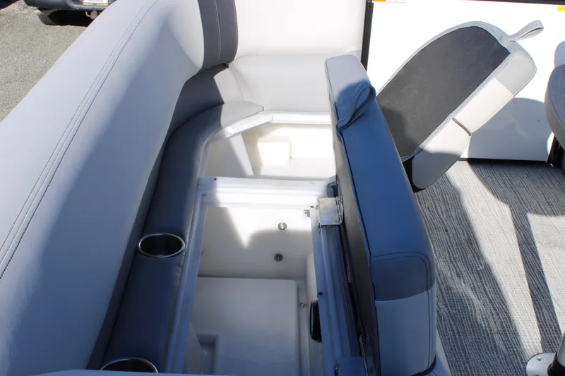 Slide: The Image of 2025 SunCatcher Select 324RC boat interior with open storage compartment and cup holders. - 19
