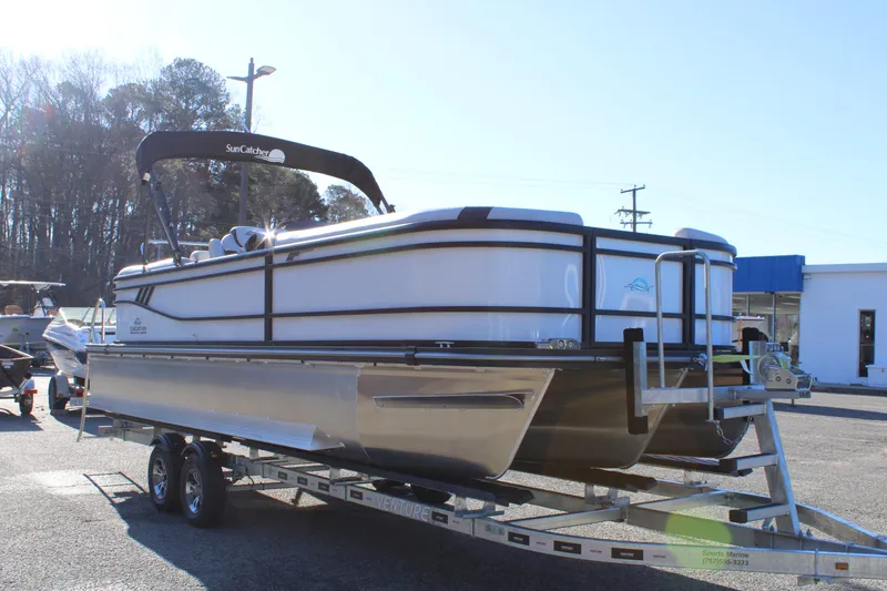 Slide: The Image of 2025 SunCatcher Select 324RC pontoon boat on trailer, parked outdoors. - 2