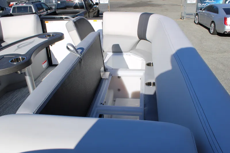 Slide: The Image of 2025 SunCatcher Select 324RC boat interior with open storage compartment and seating. - 20