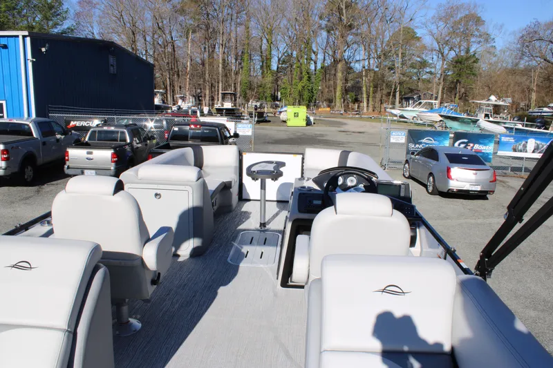 Slide: The Image of 2025 SunCatcher Select 324RC pontoon boat with spacious seating, parked outdoors. - 24