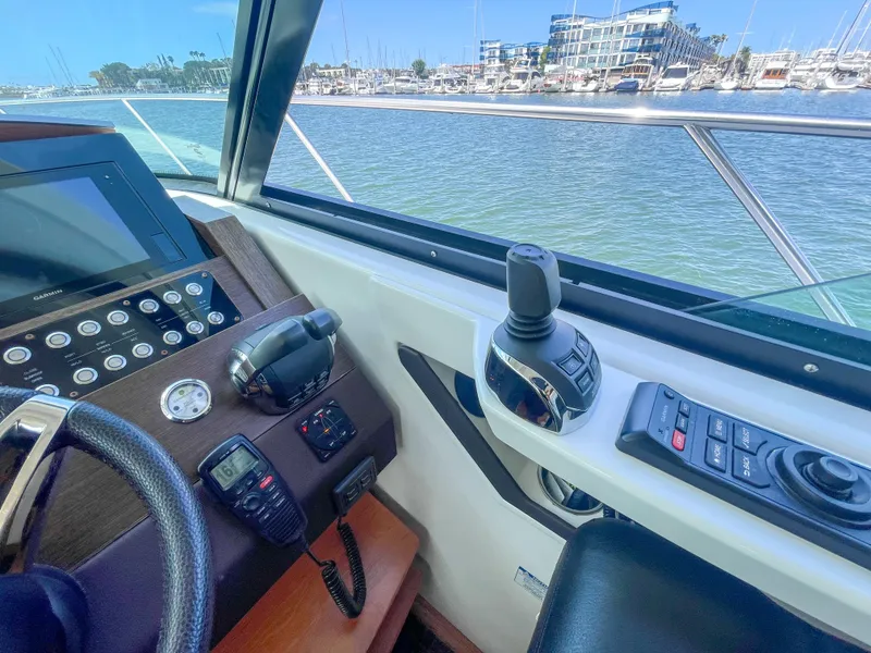 Slide: The Image of 2017 Tiara Yachts 44 Coupe helm with controls and marina view. - 27