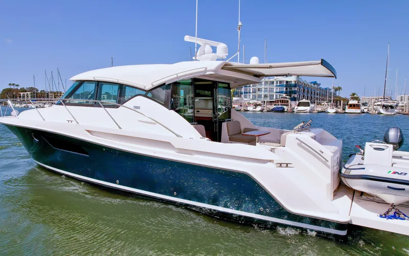 Slide: The Image of 2017 Tiara Yachts 44 Coupe in marina, sleek design, open deck, calm waters. - 3